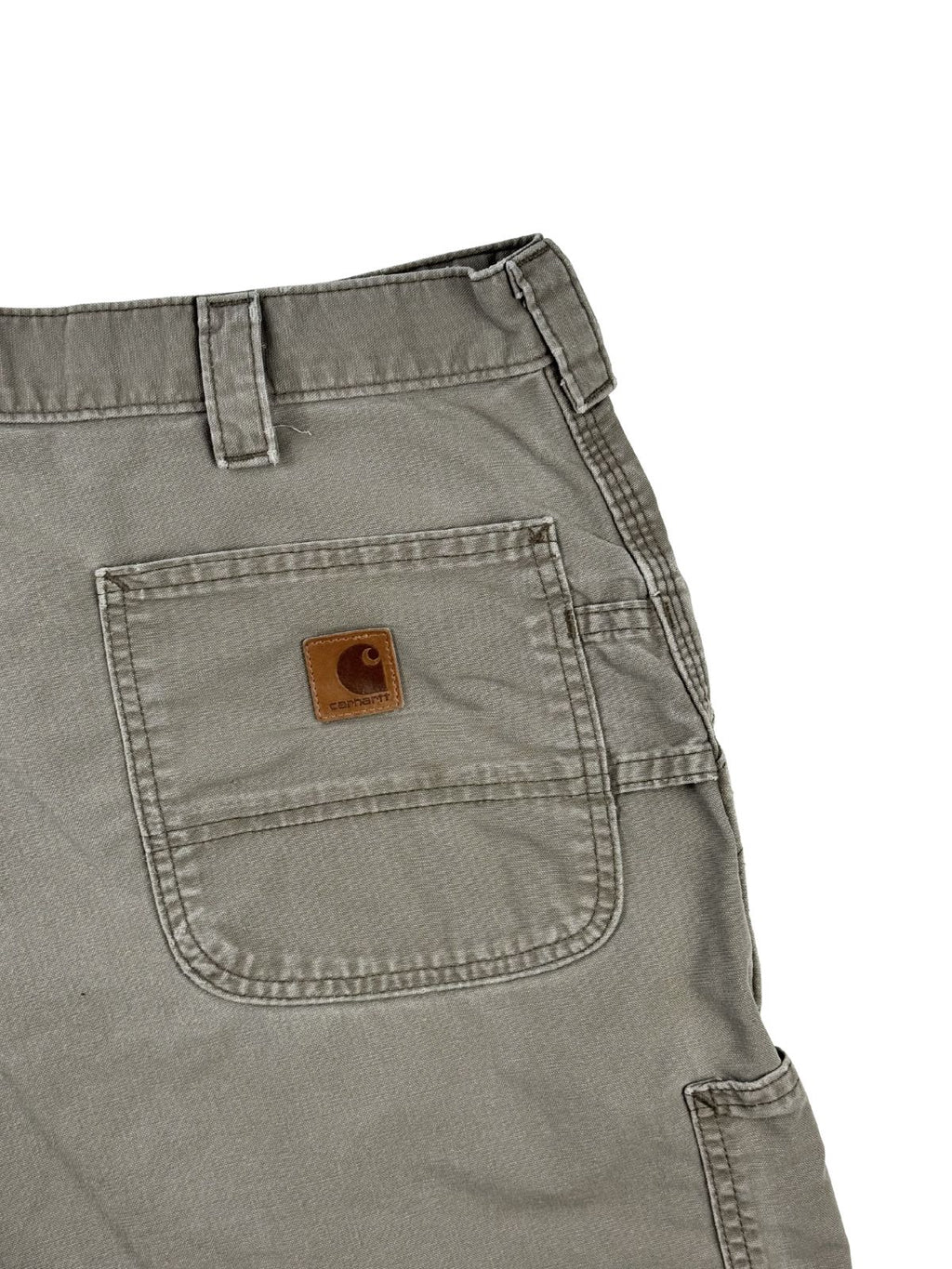 Detailansicht der hinteren rechten Tasche mit dem originalen, braunen Carhartt Leder-Logopatch auf olivgrünem Untergrund.