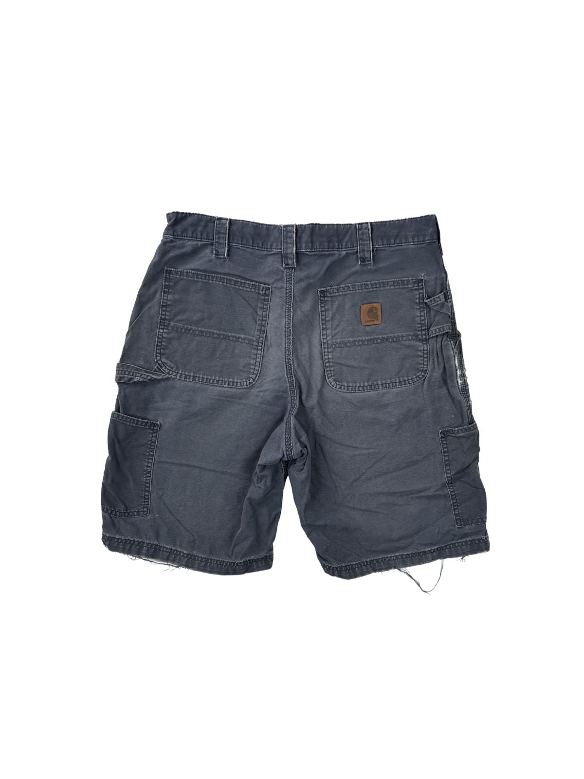 Rückansicht einer verwaschenen dunkelblauen Carhartt Carpenter Shorts mit charakteristischem Logo-Patch und authentischen Gebrauchsspuren am Saum.