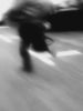 Ein schwarz weißes Cam Corder Video von einer Person die über eine Straße rennt.
