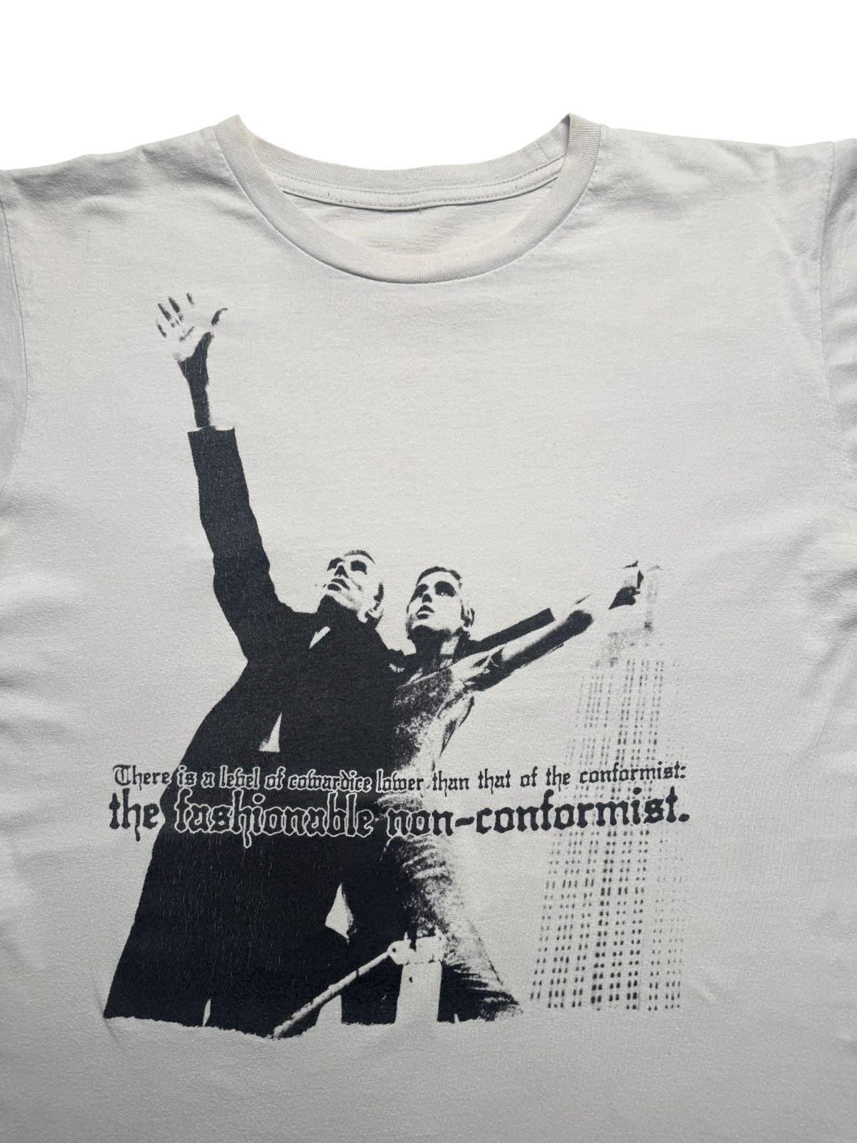 Detailansicht der vorderen Brustpartie mit Rundhalsausschnitt und dem ausführlichen Siebdruck-Text („There is a level of cowardice lower than that of the conformist: the fashionable non-conformist.“).
