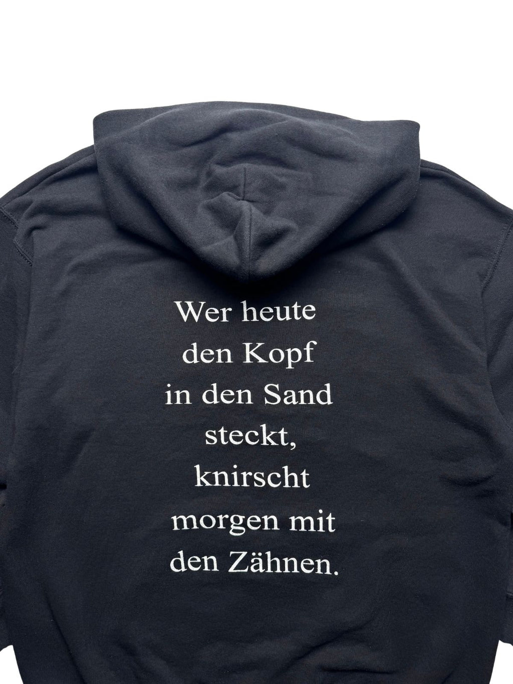Nahaufnahme der oberen Rückseite mit Blick auf die Kapuze und den zentrierten weißen Spruch-Print.