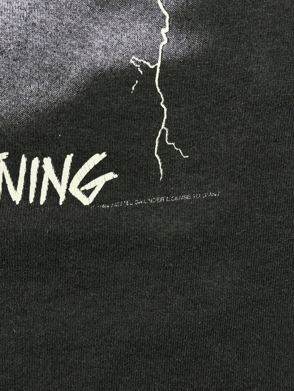 Detailaufnahme des weißen Copyright-Aufdrucks von 1994 unter dem „Ride the Lightning“-Schriftzug auf einem schwarzen Vintage-Metallica-Hoodie.