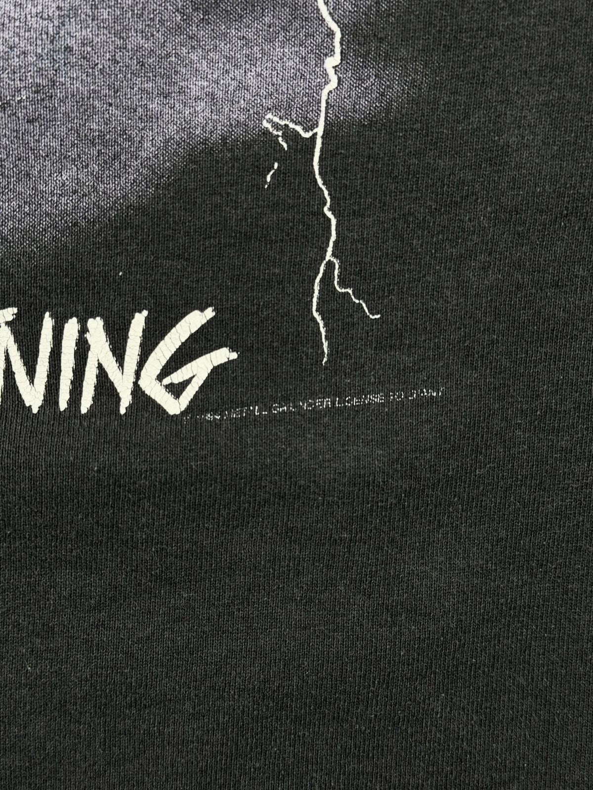 Detailaufnahme des weißen Copyright-Aufdrucks von 1994 unter dem „Ride the Lightning“-Schriftzug auf einem schwarzen Vintage-Metallica-Hoodie.