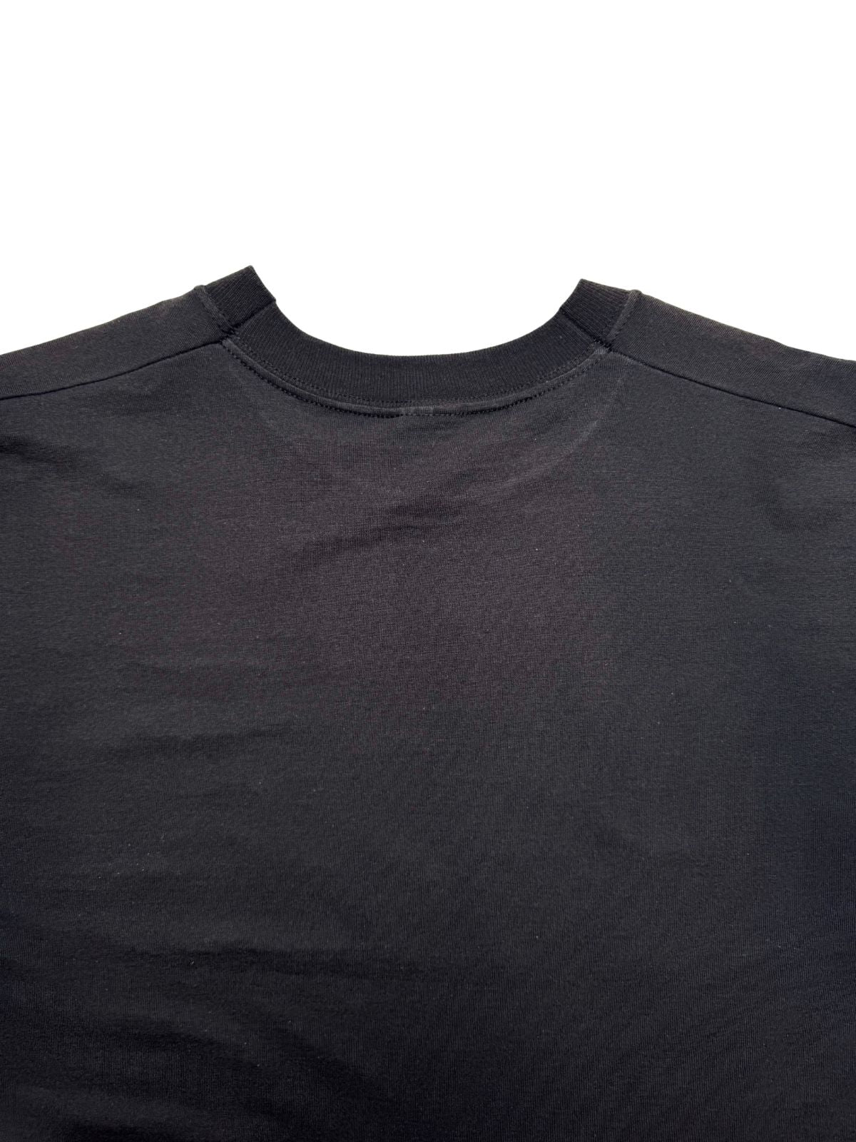 Detailansicht der oberen Rückseite mit Fokus auf die saubere Kragennaht und die schwarze Baumwoll-Stoffstruktur.