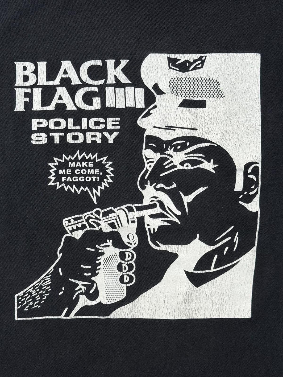 Hochauflösende Detailansicht des Raymond-Pettibon-Grafikprints auf der Brust, das eine Person zeigt, die eine Waffe auf einen Polizisten richtet (Police Story Artwork).