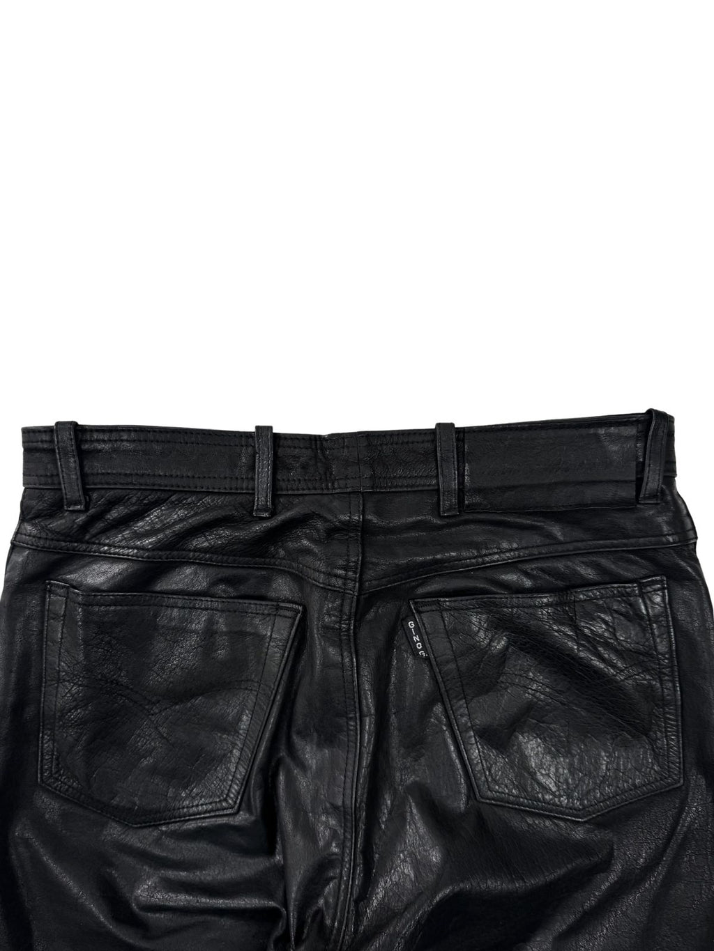 Rückwärtiger Bund der schwarzen Lederhose mit Gürtelschlaufen und Gino Ginero Logo-Fähnchen an der Tasche.