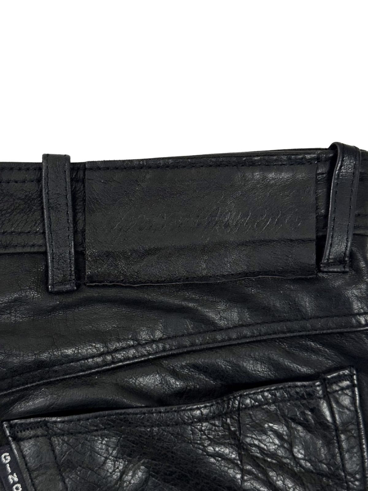 Geprägtes Leder-Patch der Marke Gino Ginero am hinteren Bund der schwarzen Vintage Echtlederhose.