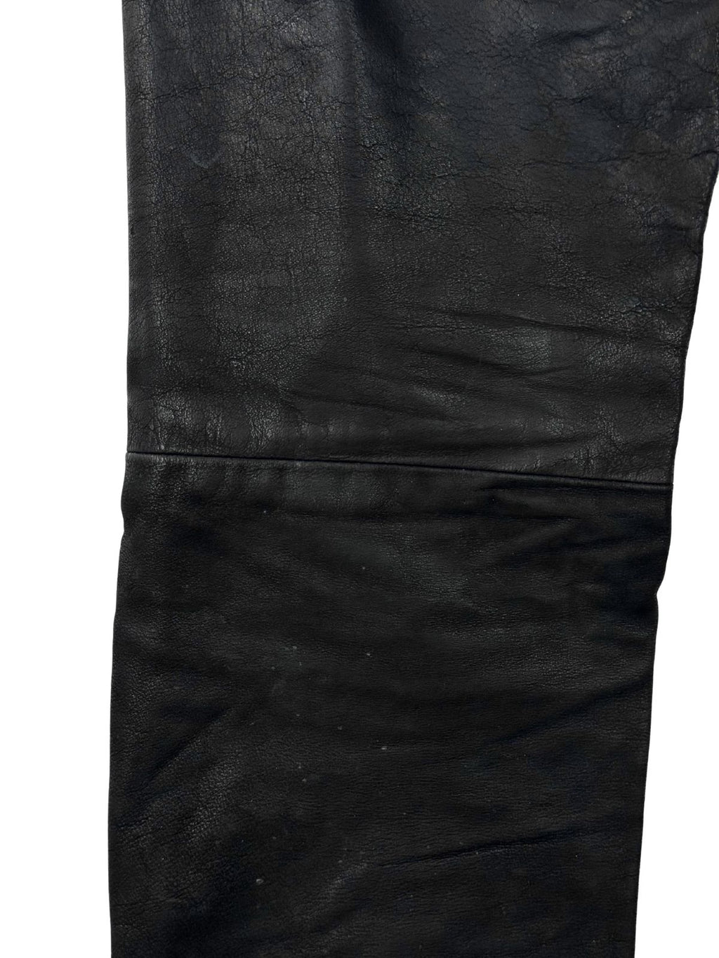 Detailaufnahme der horizontalen Knienaht und der Narbenstruktur des schwarzen Echtleders bei einer Vintage Bikerhose.