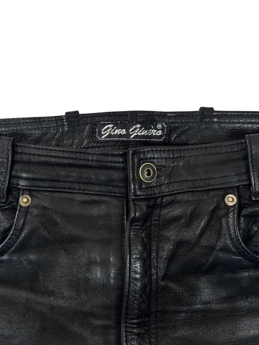 Nahaufnahme des Gino Ginero Markenlabels am inneren Hosenbund einer schwarzen Vintage Bikerhose.