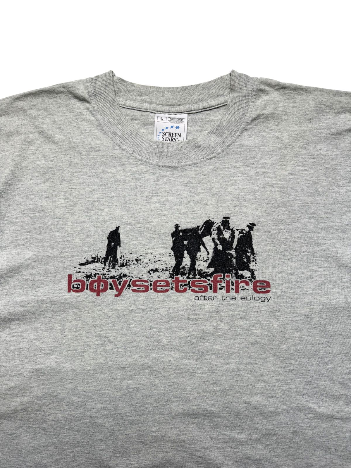 Nahaufnahme der oberen Vorderseite des Bandshirts mit dem gerippten Rundhalskragen und dem eingenähten weißen Nackenetikett der Marke Screen Stars.