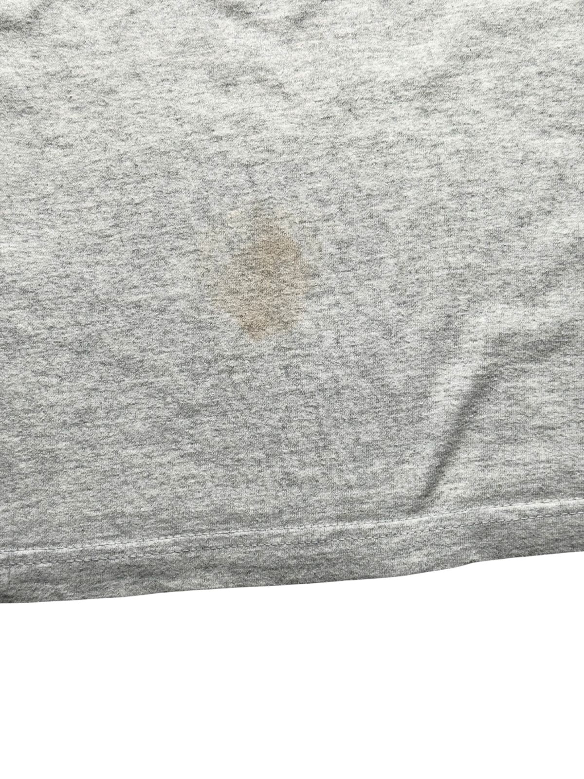 Detailansicht der unteren Rückseite knapp über der Bundnaht, die einen weiteren bräunlichen Fleck zur transparenten Zustandsdokumentation zeigt.