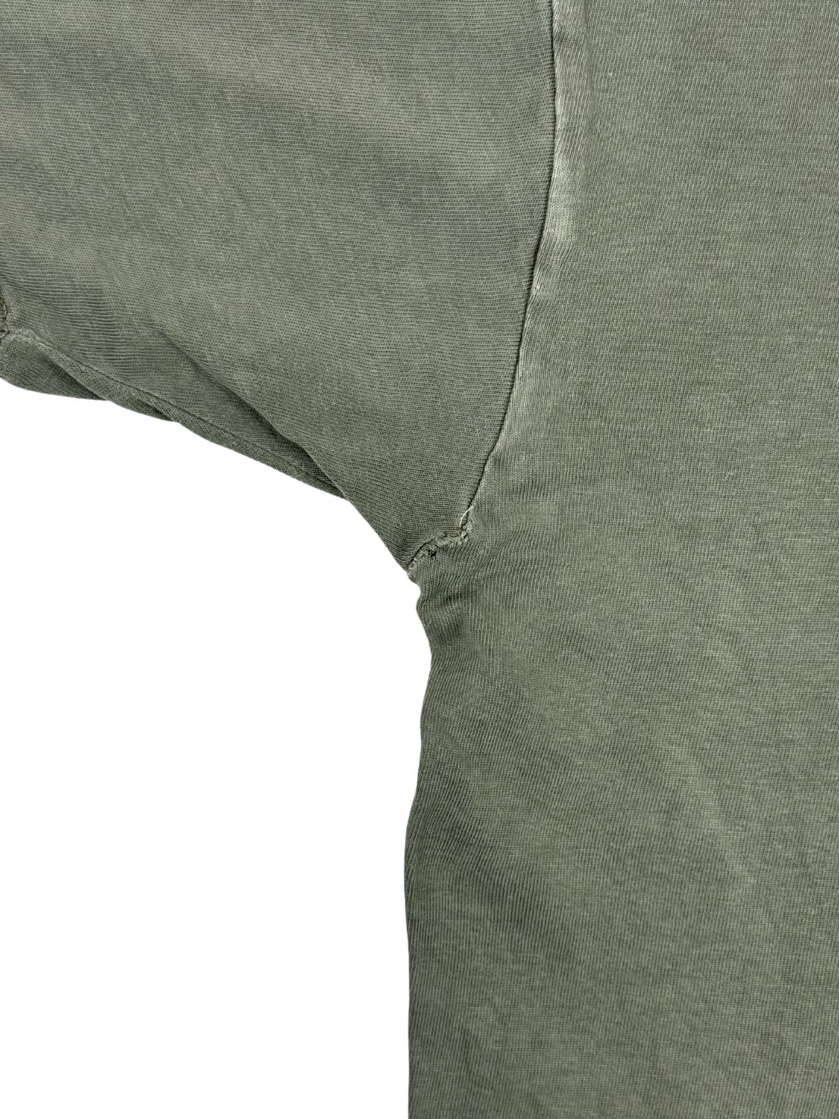 Detailansicht der hinteren linken Achselnaht mit leichten Dehnungsspuren im olivgrünen Baumwollstoff.