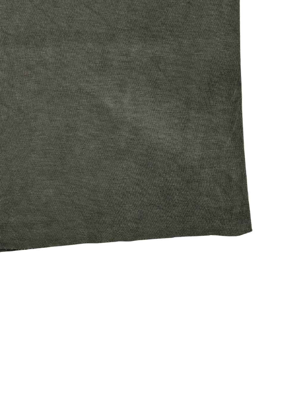 Detailaufnahme des abgeschnittenen, offenen Saums (Raw Hem) am olivgrünen Vintage-Militär-Shirt.