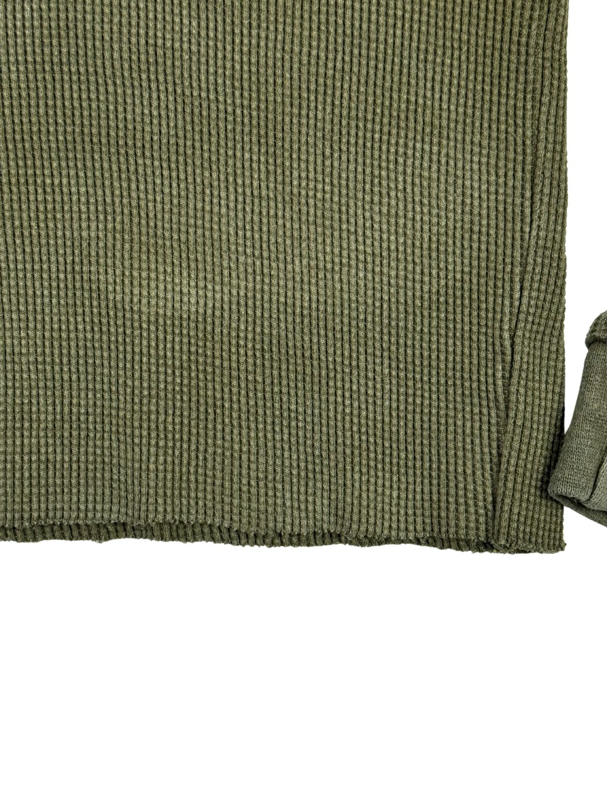 Detailaufnahme des modifizierten, abgeschnittenen Saums (Cropped/Raw Hem) am olivfarbenen Bundeswehr Kälteschutz-Shirt.