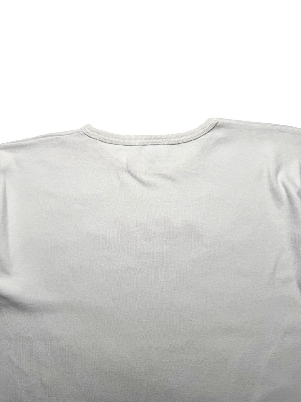 Detailansicht der oberen Rückseite mit Fokus auf die feine Nackennaht des hellen Baumwoll-Shirts.