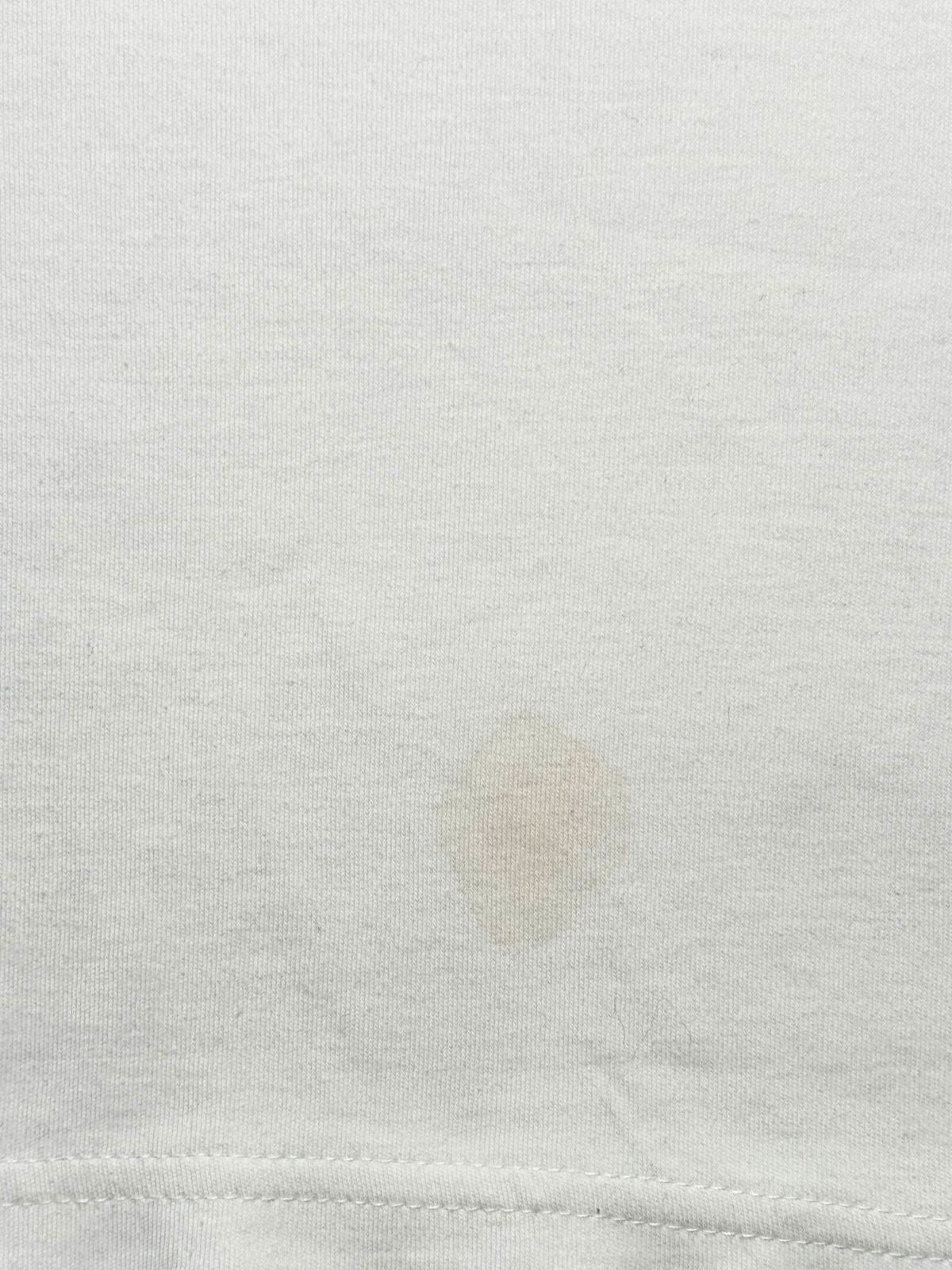 Detailaufnahme des weißen Baumwollstoffs zur transparenten Zustandsdokumentation mit einem leichten, blassbraunen Fleck im unteren Bereich.