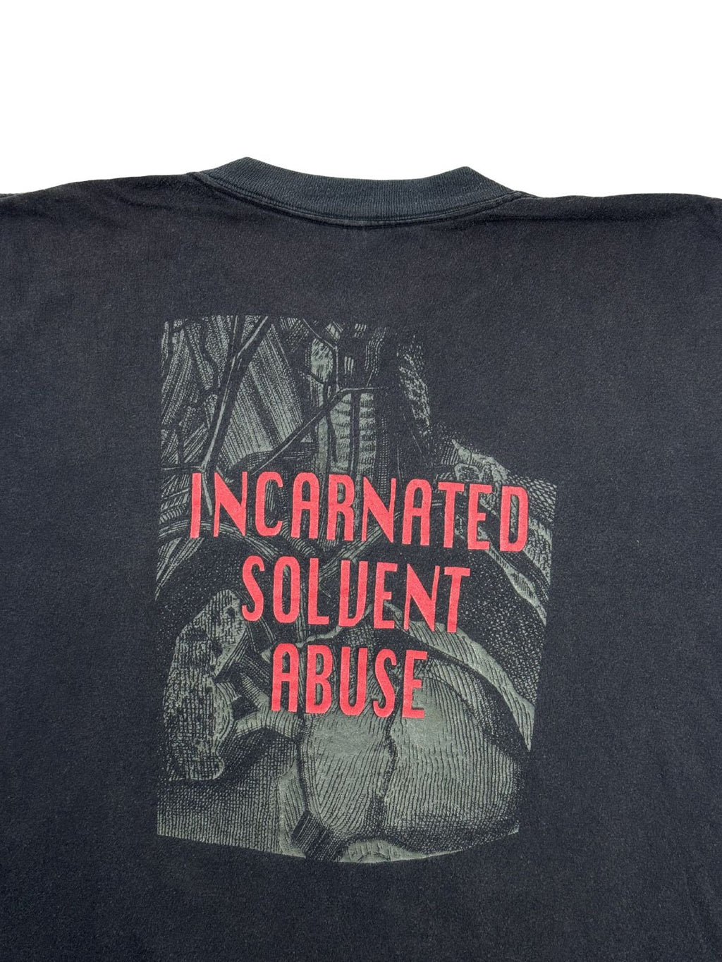 Detaillierte Nahaufnahme des Backprints auf dem 1991er Carcass Tank Top. Zu sehen ist der knallrote, dreizeilige Songtitel-Schriftzug „INCARNATED SOLVENT ABUSE“ über einer anatomischen Grafik, platziert auf dem verwaschenen schwarzen Baumwollstoff unterhalb des Kragens.