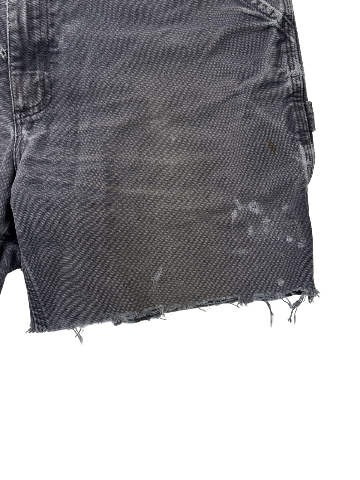 Authentische Flecken und Farbspritzer auf dem grauen Canvas-Stoff einer Vintage Carhartt Shorts (linke Vorderseite).