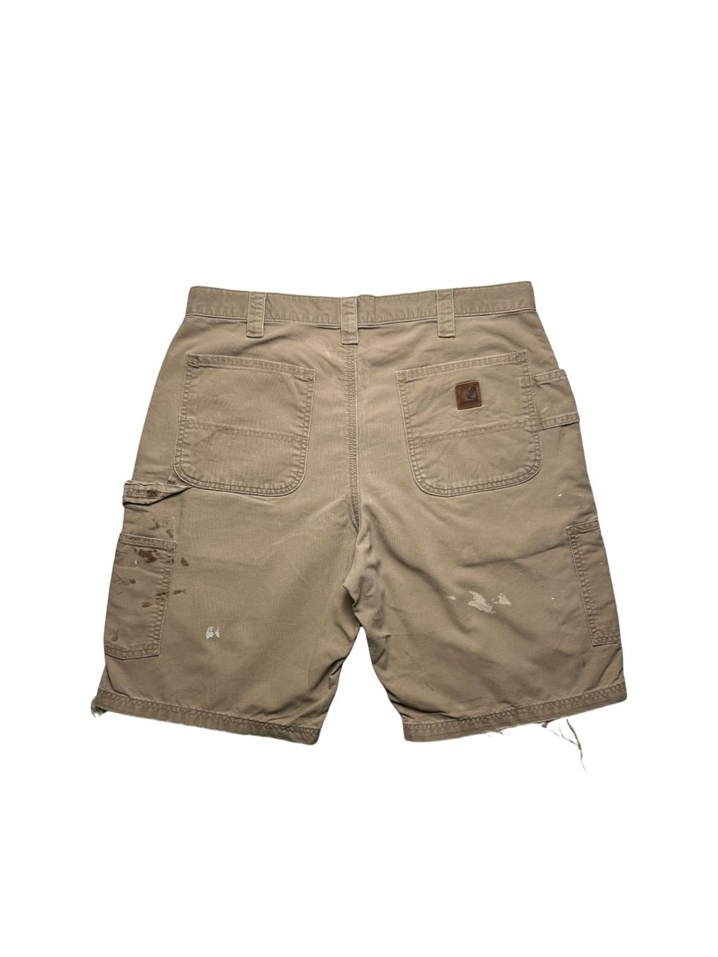 Rückseite der beigen Vintage Carhartt Shorts in der Gesamtansicht mit aufgesetzten Gesäßtaschen, Werkzeugtaschen und ausgeprägten Farb- und Fleckenstrukturen.