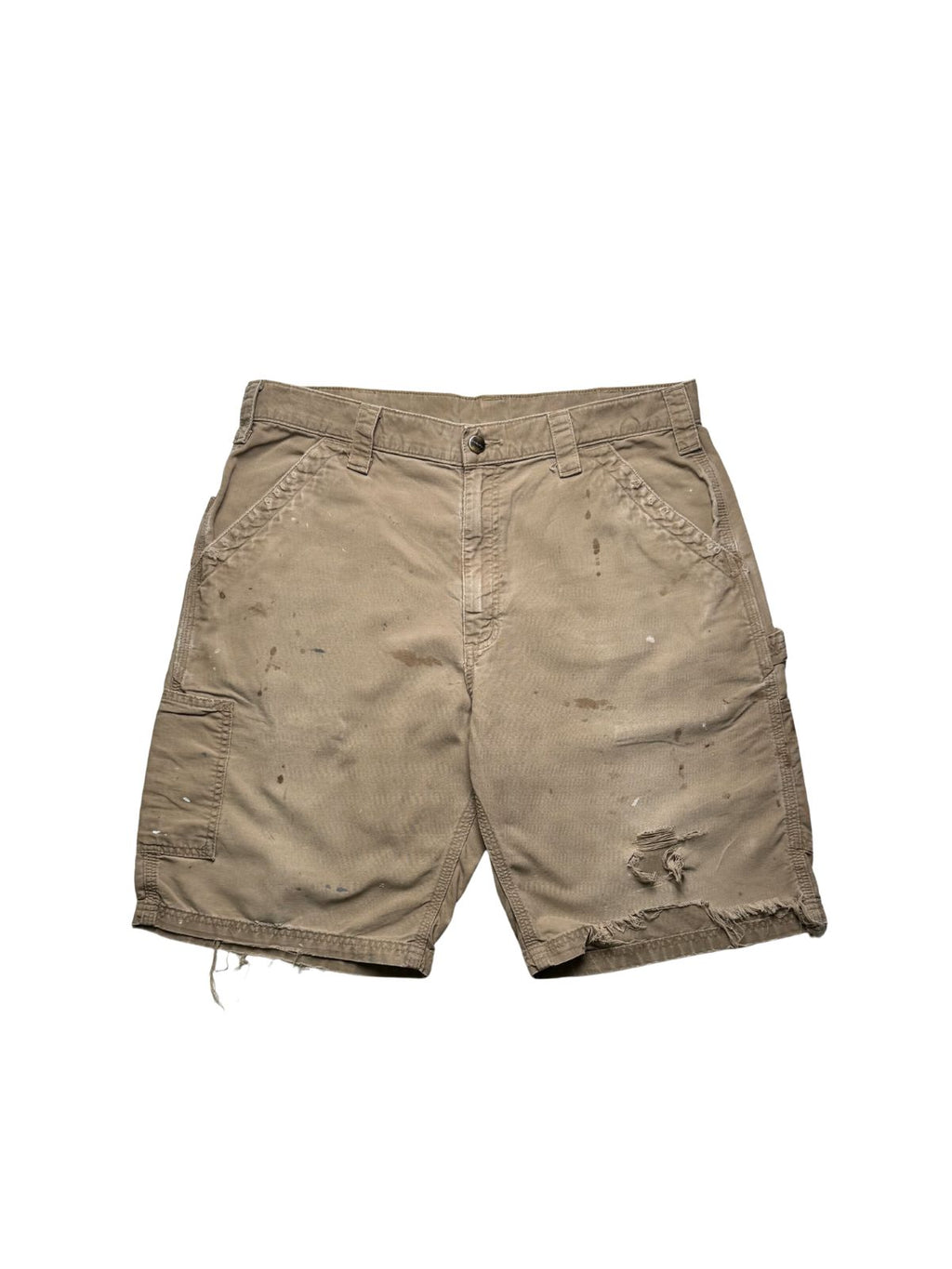 Originale Vintage Carhartt Carpenter Shorts aus festem Canvas-Stoff in ausgewaschenem Beige. Frontansicht der Workwear-Hose mit authentischen Farbspritzern und einem thrashed Loch am linken Hosenbein.