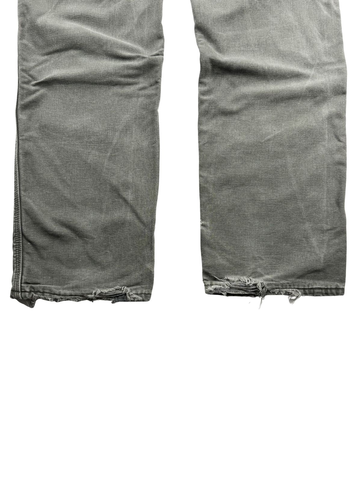 Detailansicht der hinteren Hosensäume mit starkem „Heel Bite“ (ausgefranste, kaputte Saumkanten durch das Schleifen der Hose auf dem Boden beim Gehen).