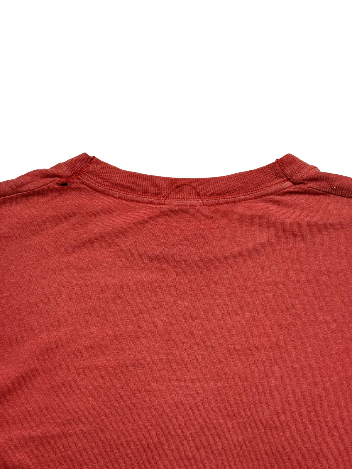 Nahaufnahme der oberen Rückseite mit Fokus auf das elastische Nackenbündchen, herausgetrennte Etikett-Fäden und das gewebte Baumwollmaterial.