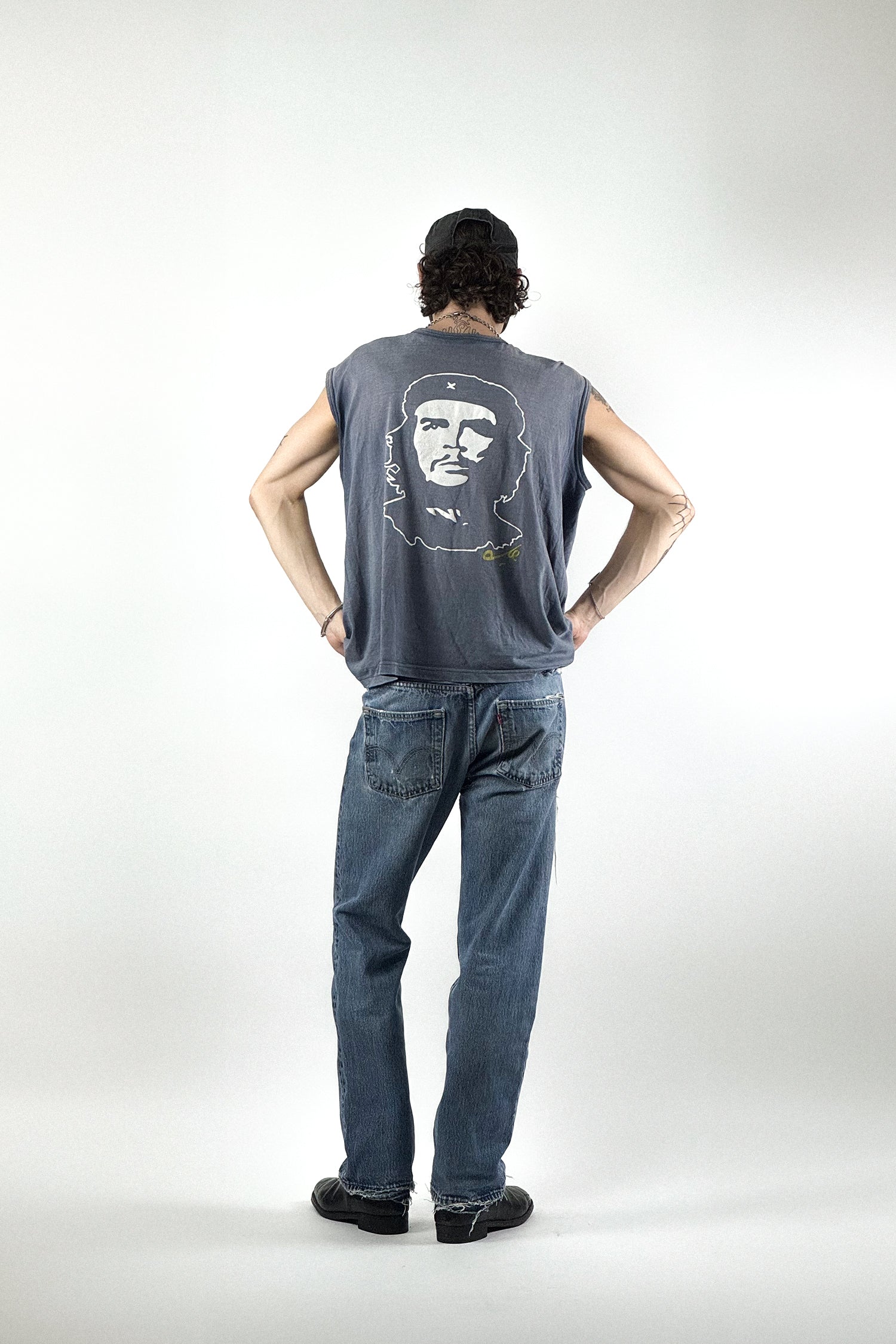 Rückansicht eines grauen Vintage Che Guevara Muskelshirts aus den 90ern, perfekt kombiniert mit einer eingetragenen blauen Levis 501 Denim.