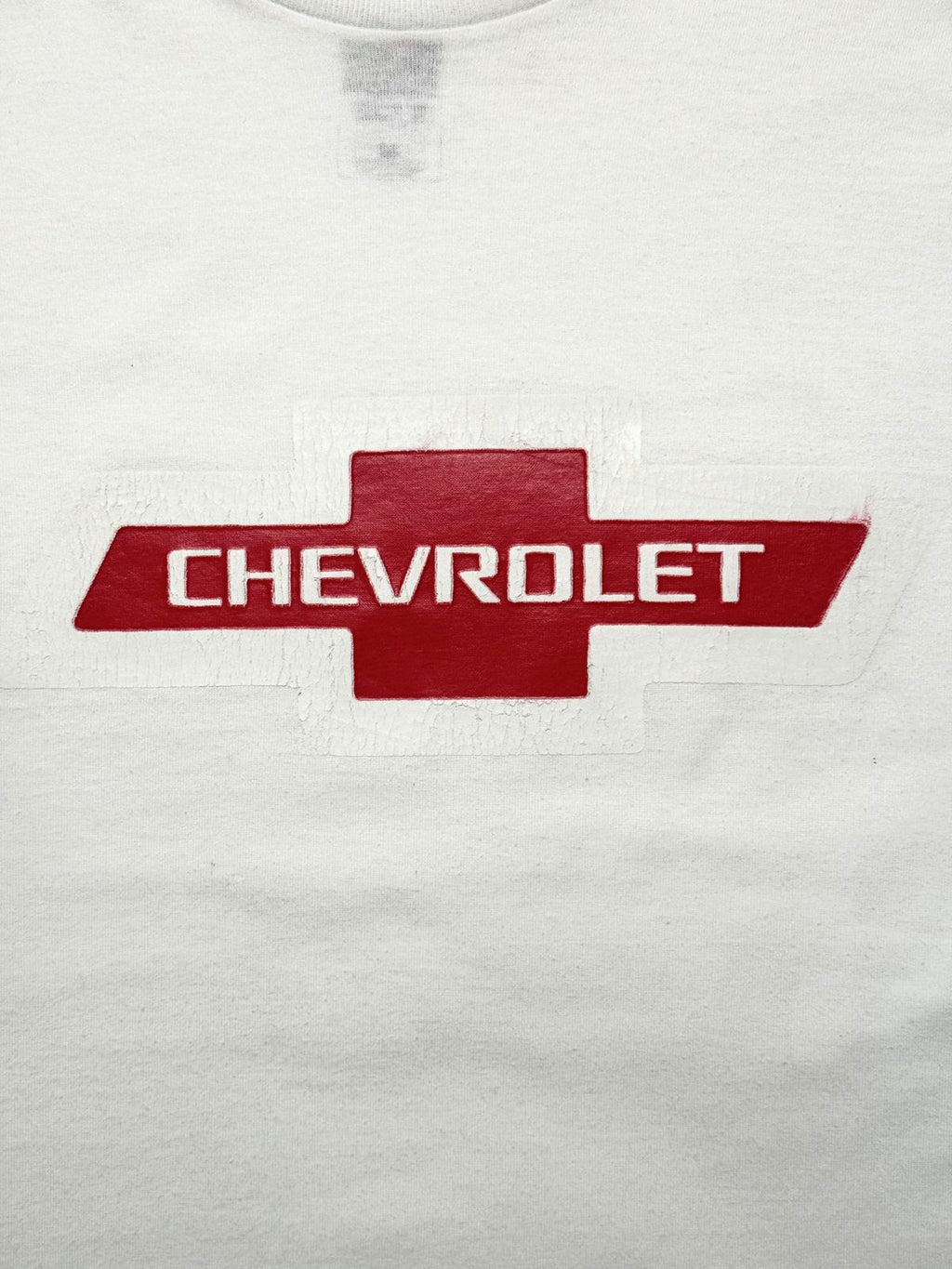 Detailansicht des vorderen Siebdrucks mit dem roten Chevrolet-Kreuz-Logo und dem weißen Markenschriftzug im gealterten Used-Look.