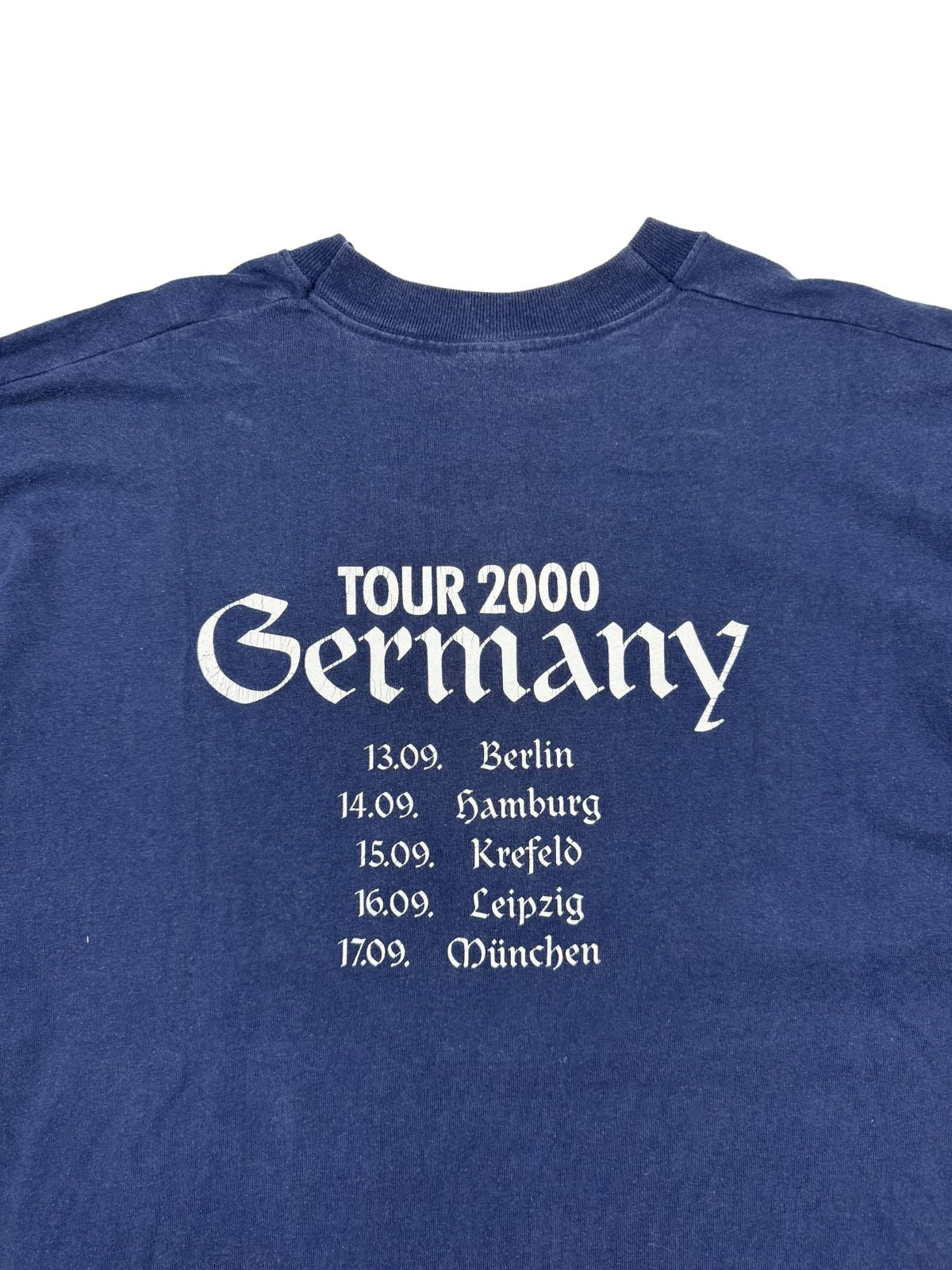 Detailansicht des weißen Siebdrucks auf der Rückseite: „Tour 2000 Germany“ in Frakturschrift auf dunkelblauem Vintage-Stoff.