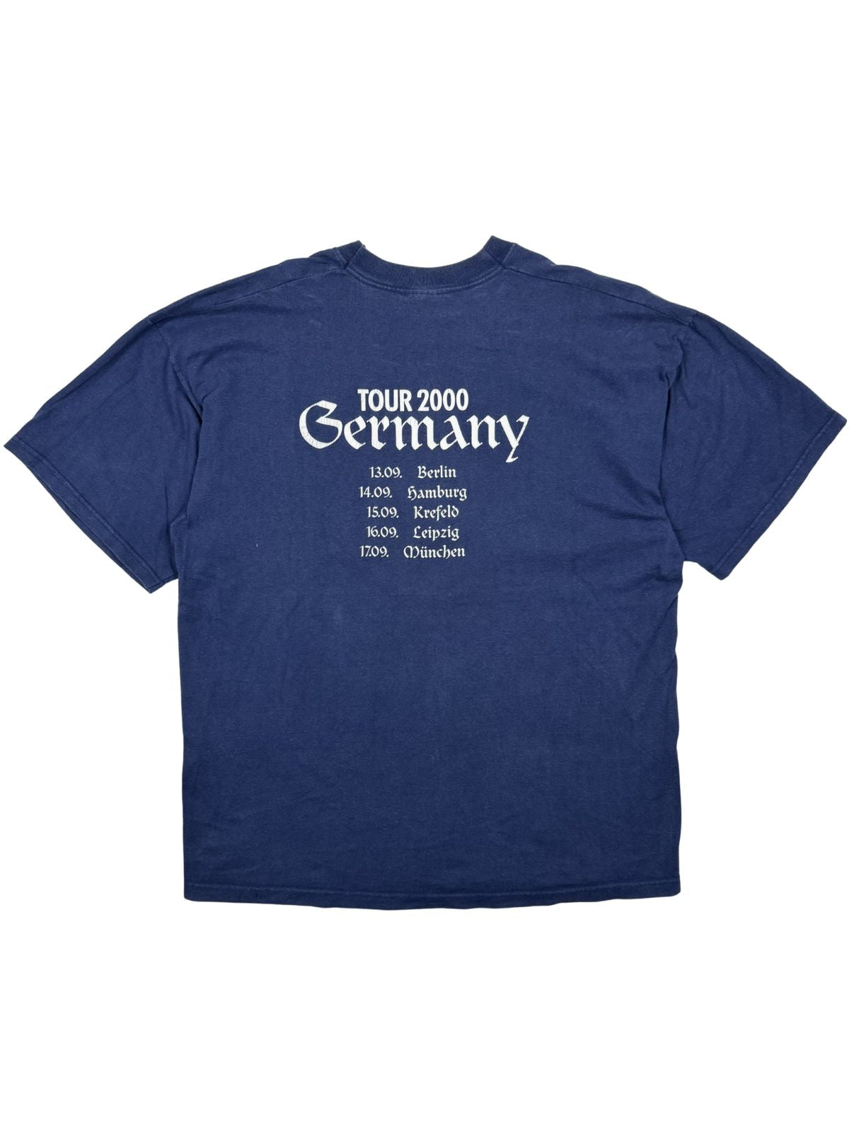 Rückseite eines dunkelblauen Cockney Rejects Vintage Band-Shirts mit der „Tour 2000 Germany“ Grafik und einer Liste deutscher Konzertstädte (Berlin, Hamburg, Krefeld, Leipzig, München).