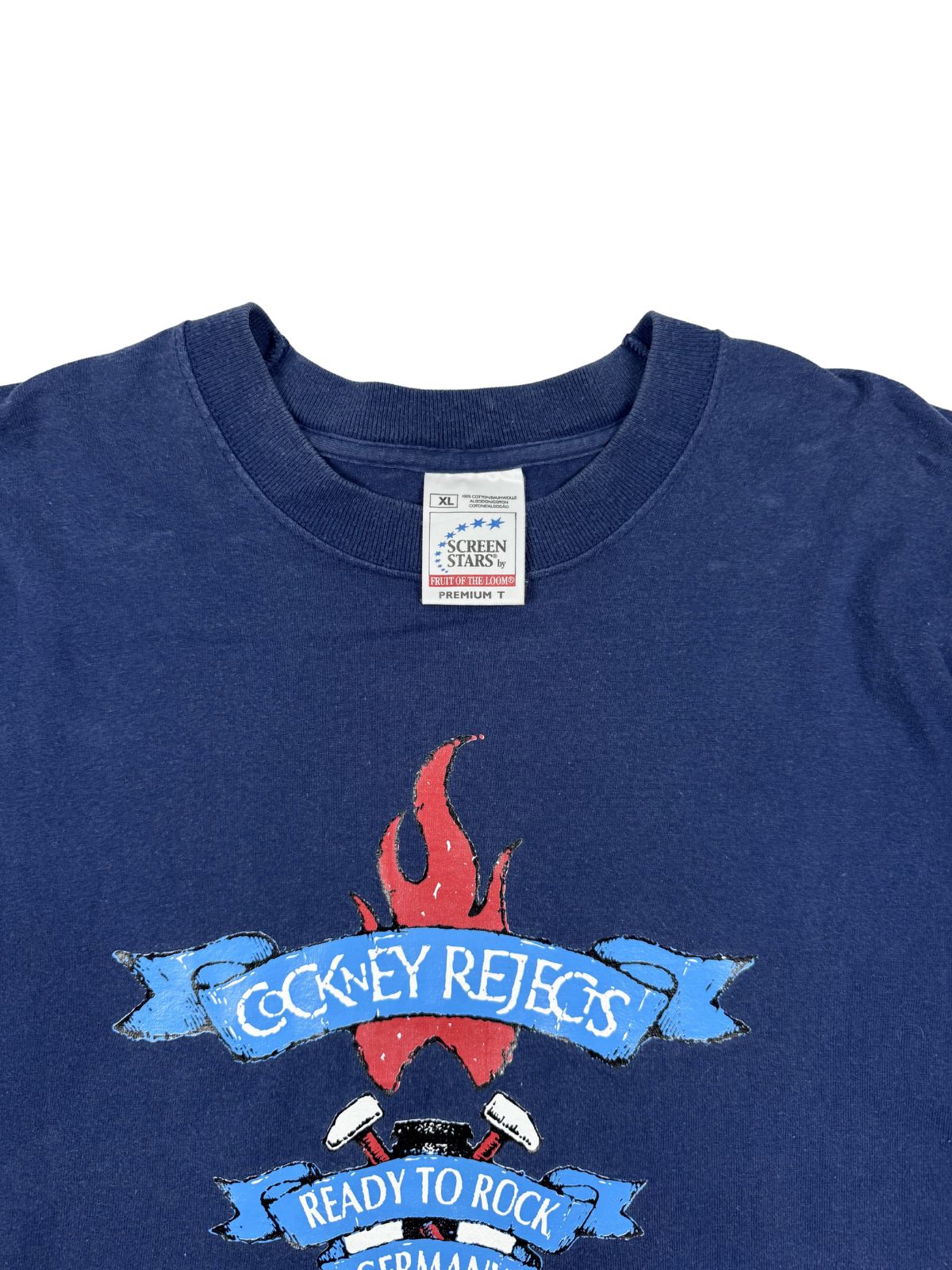 Nahaufnahme des Nackenetiketts: Weißes „Screen Stars by Fruit of the Loom Premium T“ Tag, Größe XL, in einem dunkelblauen Baumwollshirt.
