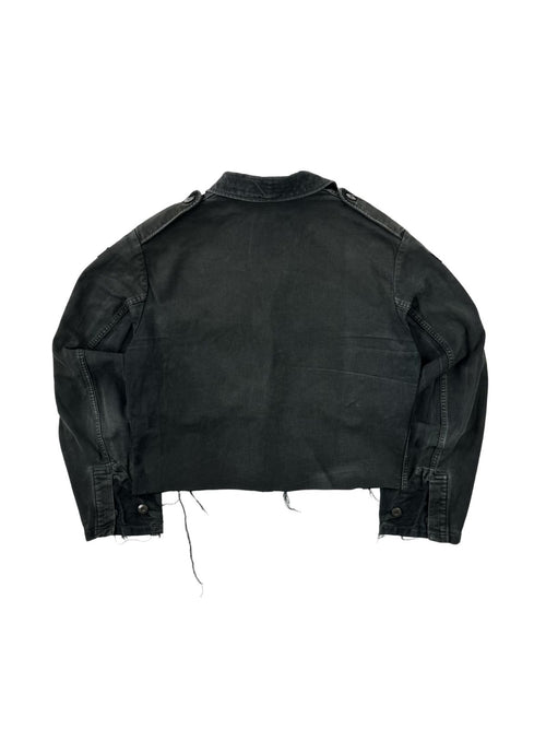 Rückansicht einer umgearbeiteten (cropped) Vintage Bundeswehr Feldjacke aus den 1980er Jahren in verwaschenem Schwarz. Die Militärjacke wurde am Saum kurz abgeschnitten und zeigt Fransen im Distressed-Look. Flatlay auf weißem Hintergrund.