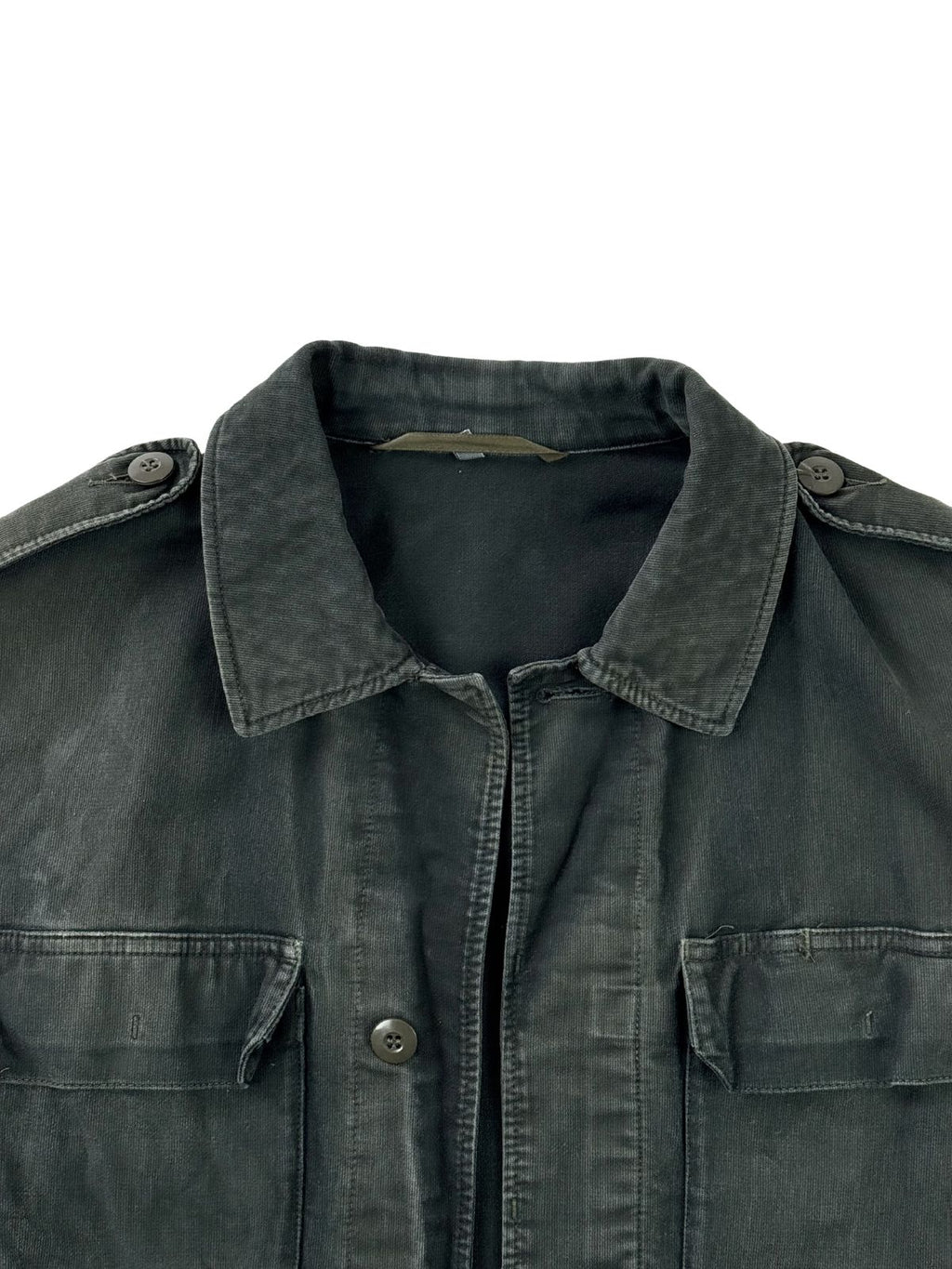Nahaufnahme des oberen Frontbereichs der schwarzen Vintage-Militärjacke. Zu sehen sind der klassische Kragen, die Knopfleiste, Schulterklappen sowie zwei Brusttaschen mit Klappen.