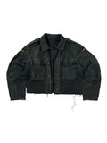 Komplettansicht der Vorderseite einer umgearbeiteten (cropped) Vintage Bundeswehr Feldjacke aus den 1980er Jahren in verwaschenem Schwarz. Die Moleskin-Jacke hat zwei große Brusttaschen, Schulterklappen, Flaggen-Patches auf den Ärmeln und einen kurz abgeschnittenen, ausgefransten Saum. Flatlay auf weißem Hintergrund.