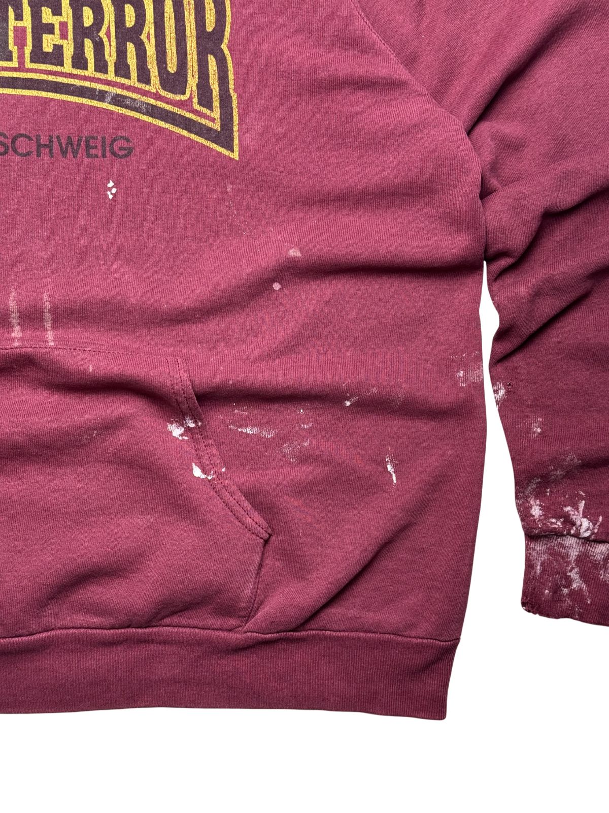 Nahaufnahme der vorderen Kängurutasche und des Saumbunds mit weißen Farbspritzern (Paint Stains) zur genauen Dokumentation des Zustands.