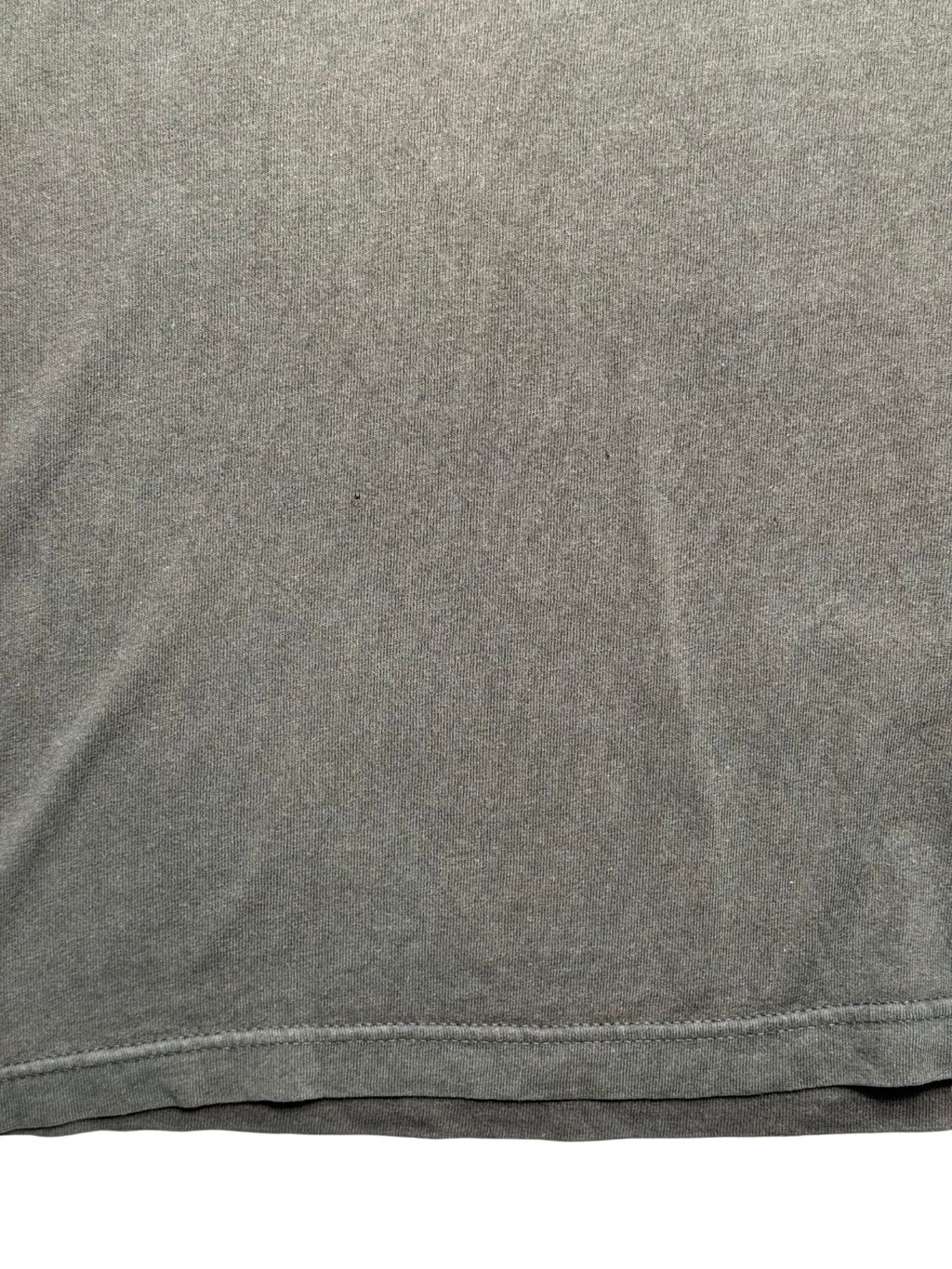Makroaufnahme der unteren Stofffläche zur transparenten Zustandsdokumentation mit einem feinen Pinhole auf dem Hemdmaterial.