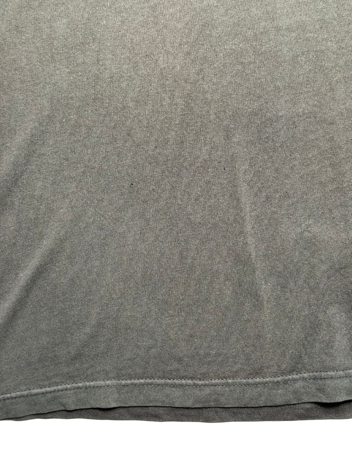 Makroaufnahme der unteren Stofffläche zur transparenten Zustandsdokumentation mit einem feinen Pinhole auf dem Hemdmaterial.