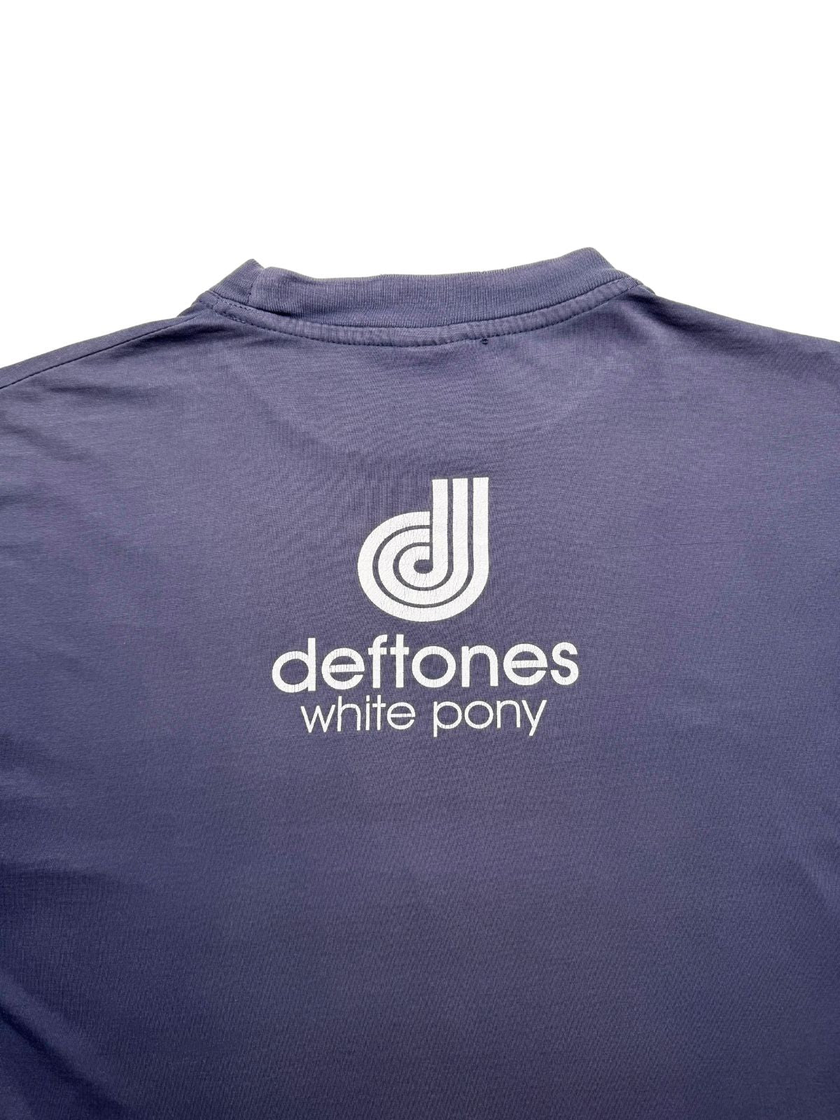 Nahaufnahme der oberen Rückseite mit Fokus auf den feinen weißen Siebdruck des runden Deftones-Logo-Icons direkt unter dem Kragen.