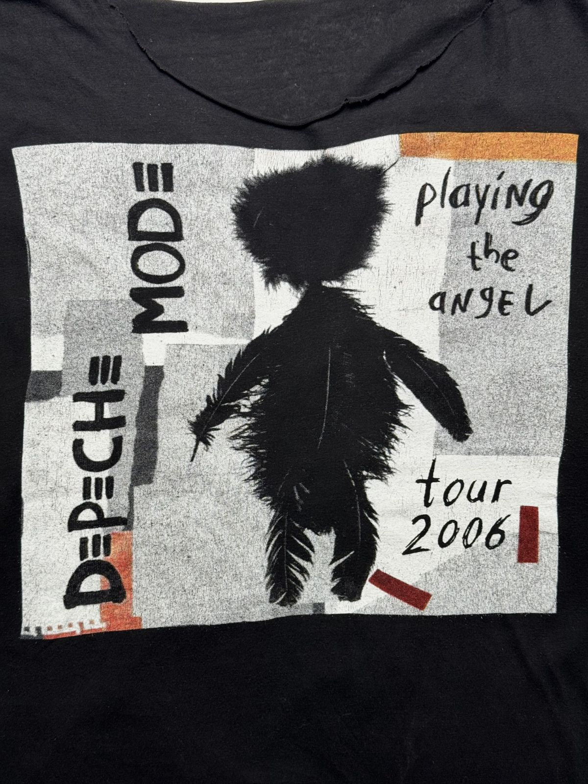 Detailansicht des vorderen Siebdrucks mit der schwarzen Feder-Figur, dem Albumtitel „playing the angel“ und dem blau-grauen „DEPECHE MODE“-Schriftzug.