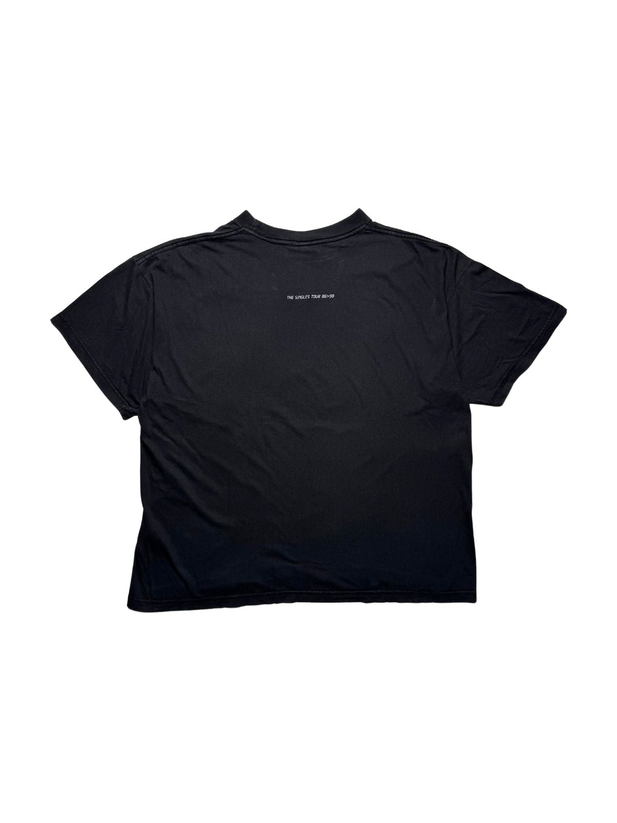 Rückseite des schwarzen Depeche Mode Vintage-Shirts von 1998 in der Gesamtansicht mit dezentem, weißem Schriftzug „THE SINGLES TOUR 86>98“ im Nackenbereich.