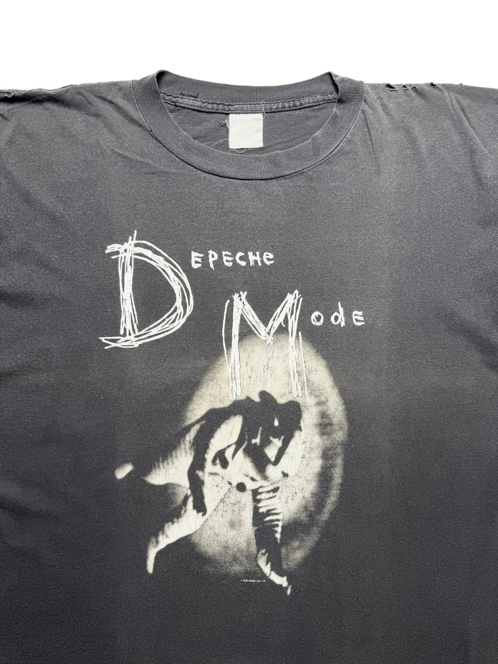 Detailansicht der vorderen Brustpartie mit dem gerippten Rundhalsausschnitt, dem weiß-grauen Fotodruck und dem Schriftzug „Depeche Mode / DM“.