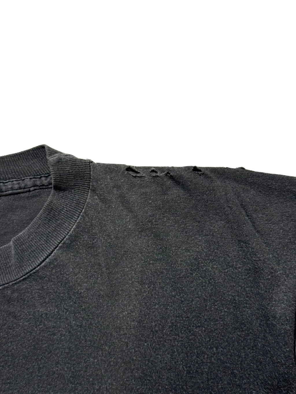 Detailaufnahme der linken Schulterpartie zur Zustandsdokumentation mit mehreren kleinen Vintage-Löchern (Thrashed Look) entlang der Naht.