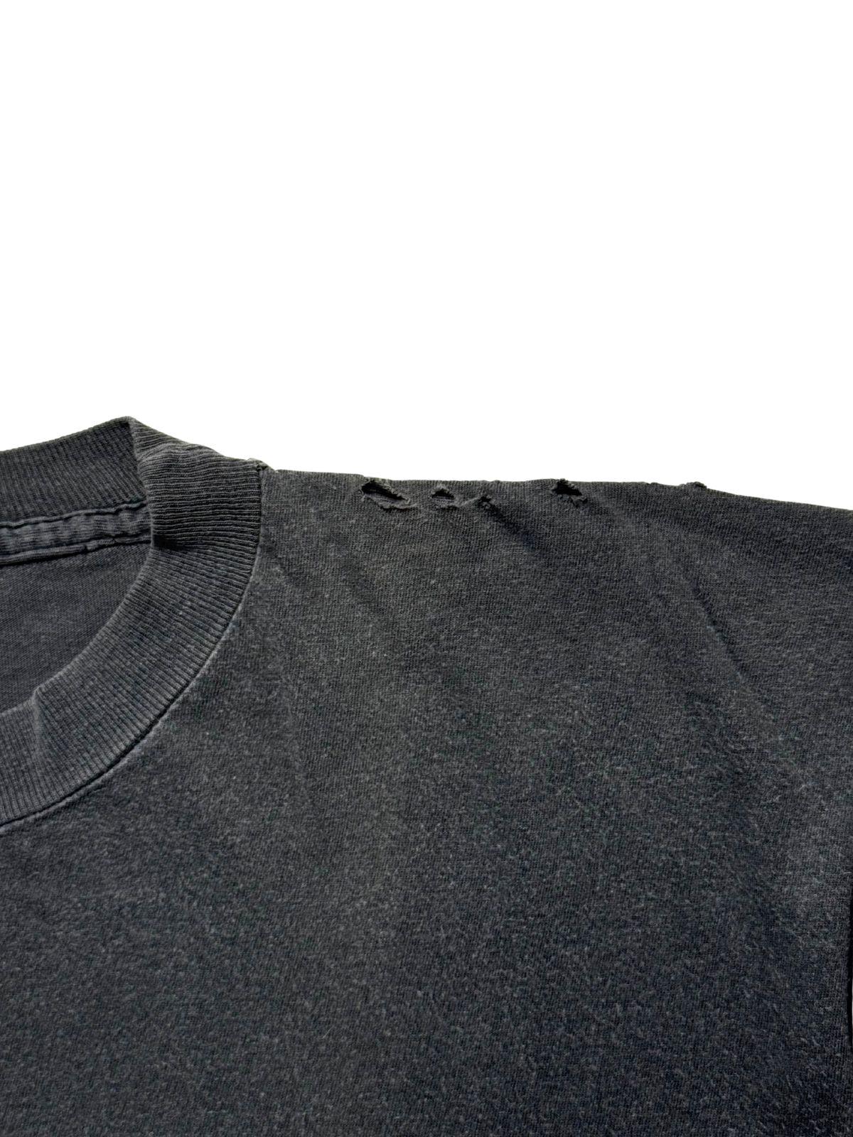 Detailaufnahme der linken Schulterpartie zur Zustandsdokumentation mit mehreren kleinen Vintage-Löchern (Thrashed Look) entlang der Naht.