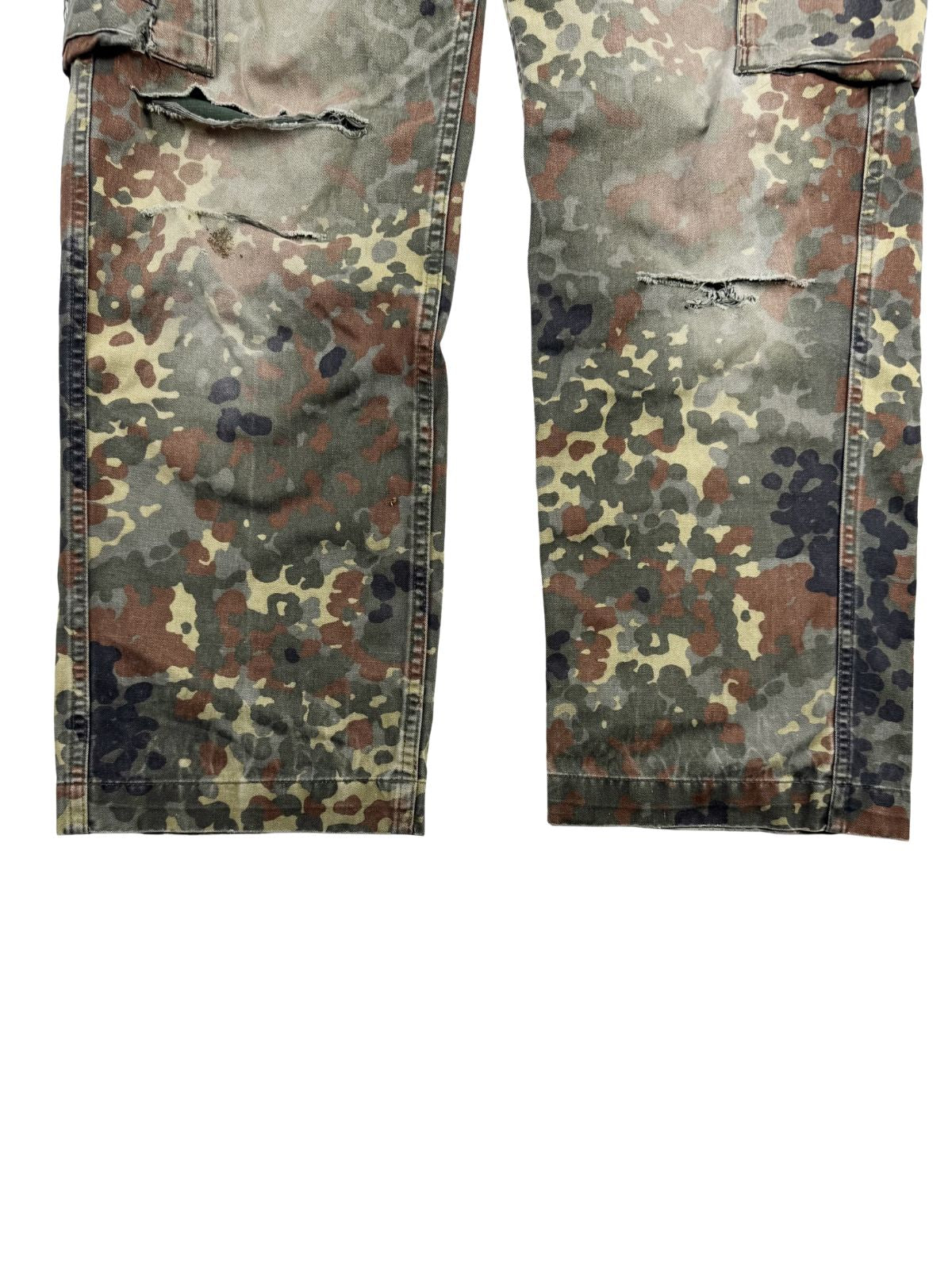 Nahaufnahme der unteren Hosenbeine von vorne zur Mängelprüfung. Gezeigt werden die starken Beschädigungen und Risse an beiden Knien im angesagten Grunge- und Vintage-Used-Look.