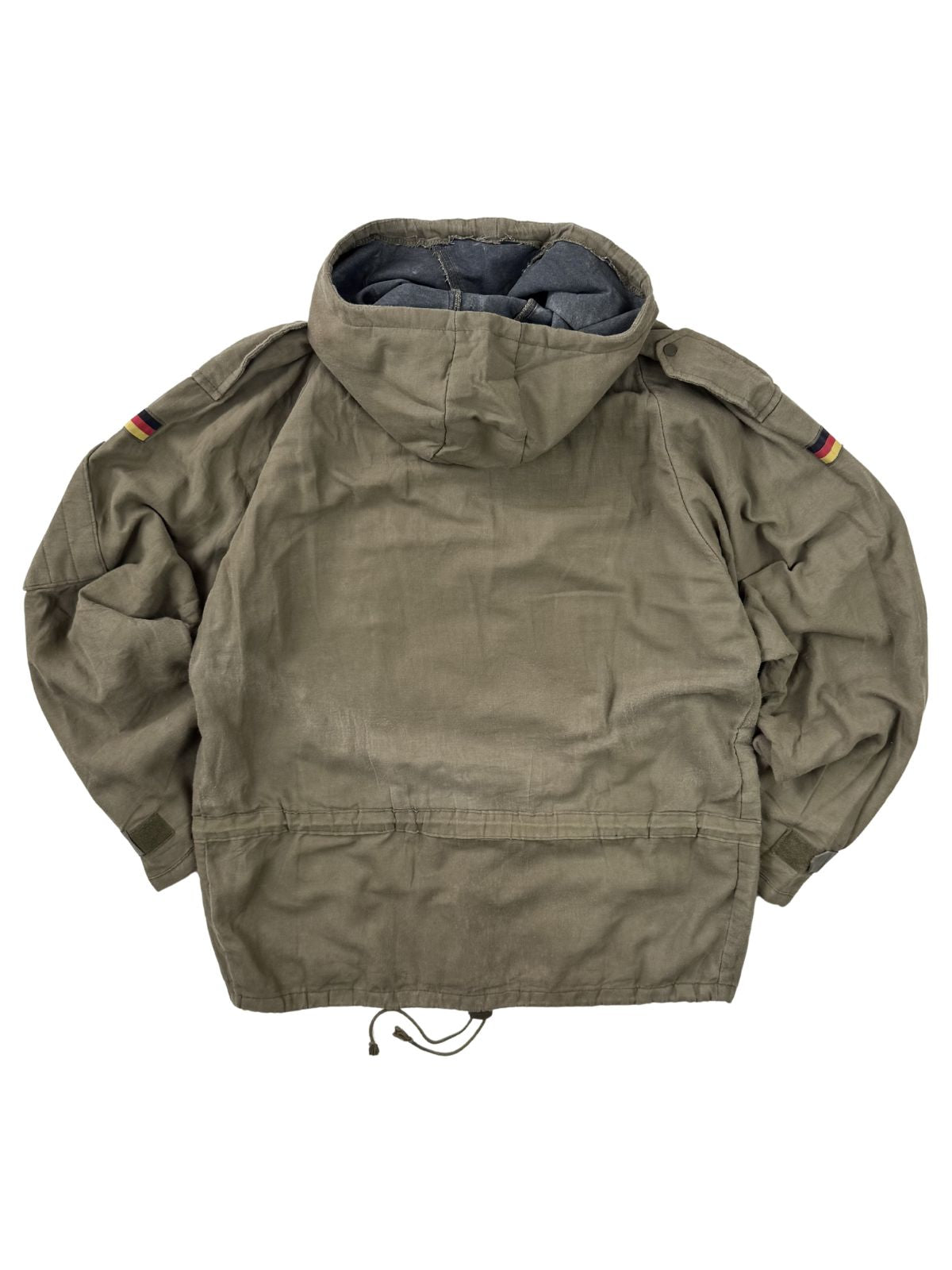 Rückansicht des olivgrünen Vintage Bundeswehr Kampf-Smocks im Flatlay. Gut erkennbar sind die Schulterklappen, der integrierte elastische Kordelzug im Taillenbereich sowie die Rückseite der Kapuze.