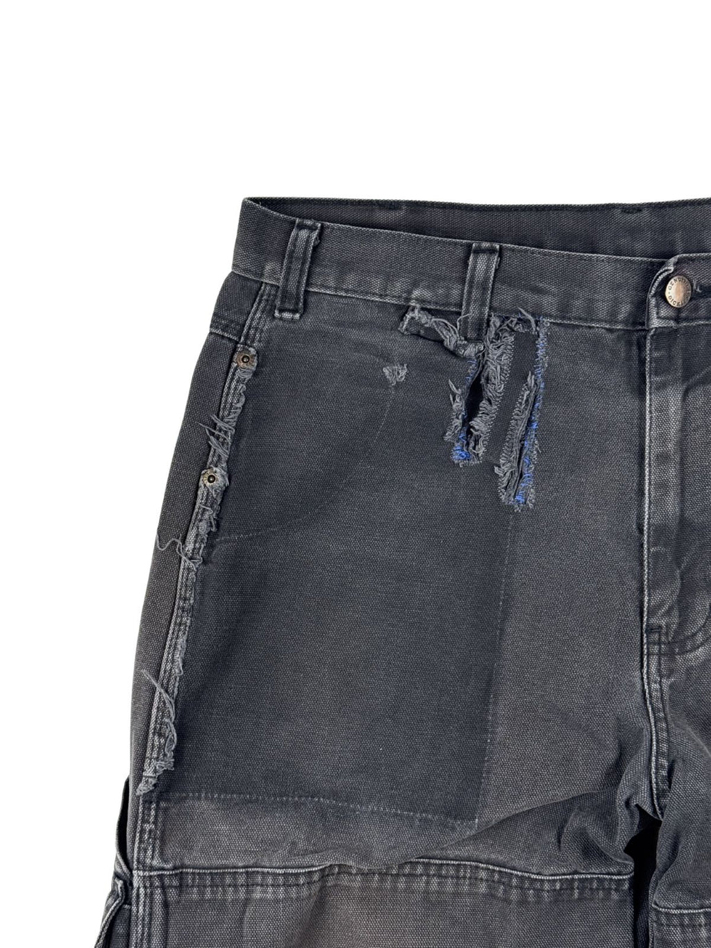 Nahaufnahme der vorderen rechten Hüftpartie mit Fokus auf die thrashed Tragespuren, den ausgefransten Riss im Canvas-Stoff, die den deutlichen Farbunterschied des „Ghost Pocket“-Stils (kontrastierender, dunklerer Stoffabdruck) im robusten Arbeitsstoff zeigt.