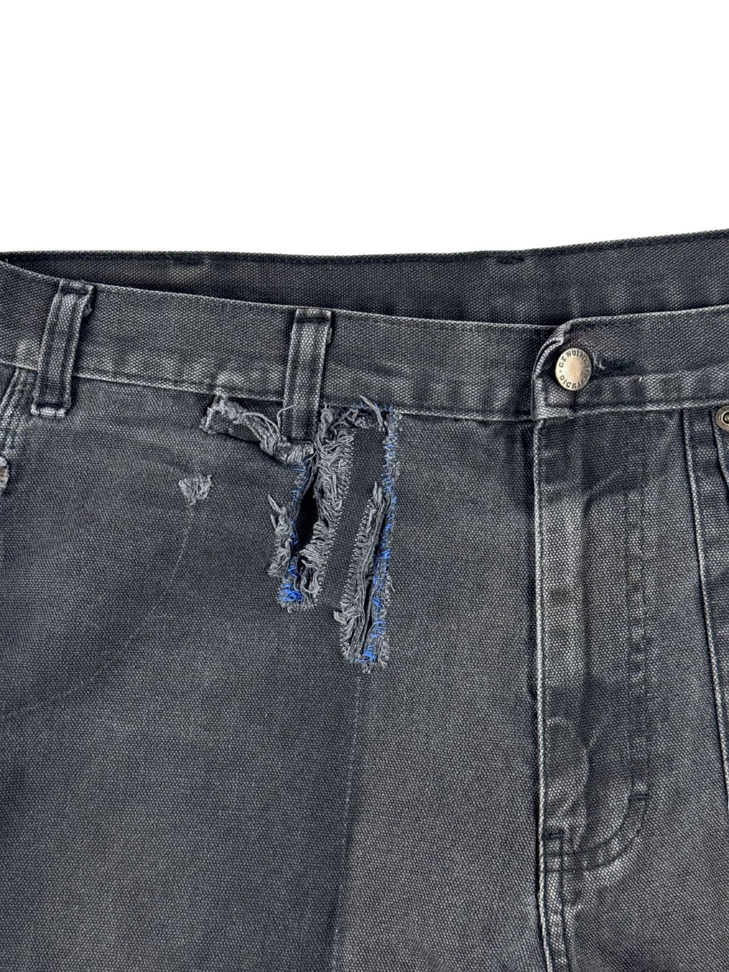 Makroaufnahme des großen, thrashed Stoffrisses unterhalb der Gürtelschlaufe, der den rauen Distressed-Charakter der Skate-Hose betont.