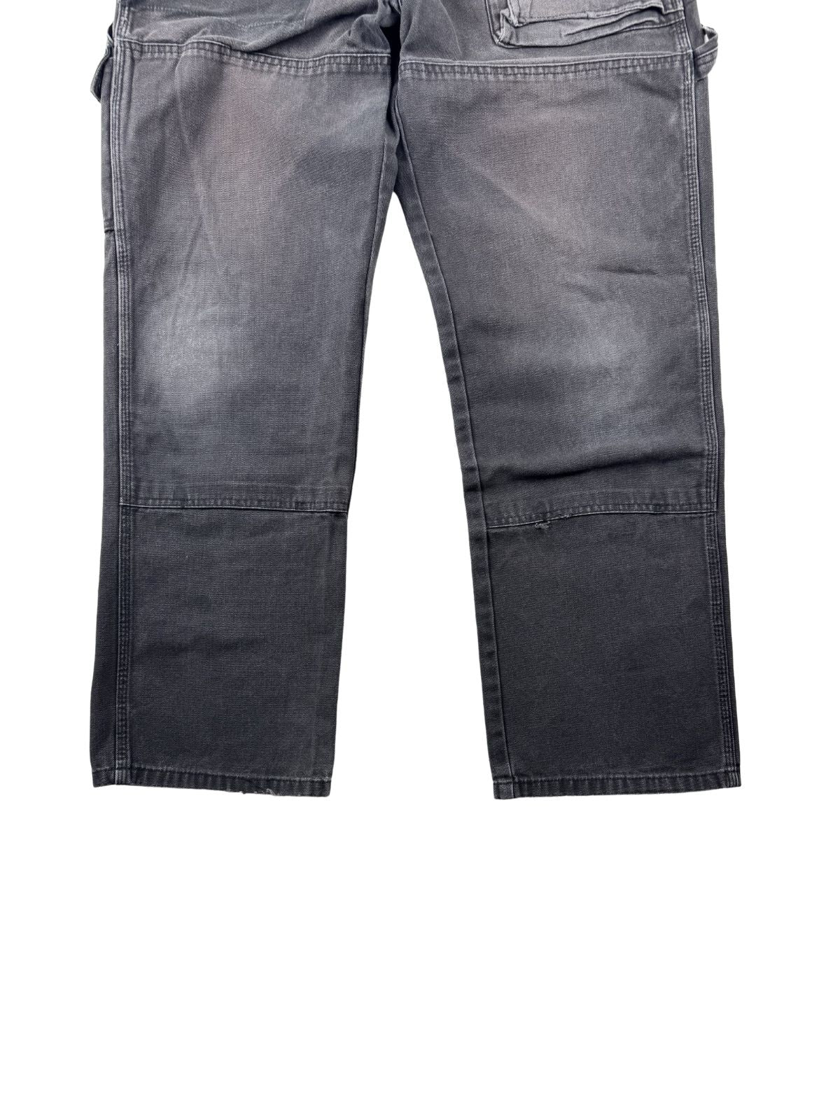 Detailansicht der vorderen Hosenbeine mit der typischen, doppellagigen Knie-Verstärkung (Double Knee), die eine authentische, hellere Ausbleichung (Fading) durch das Tragen aufweist.