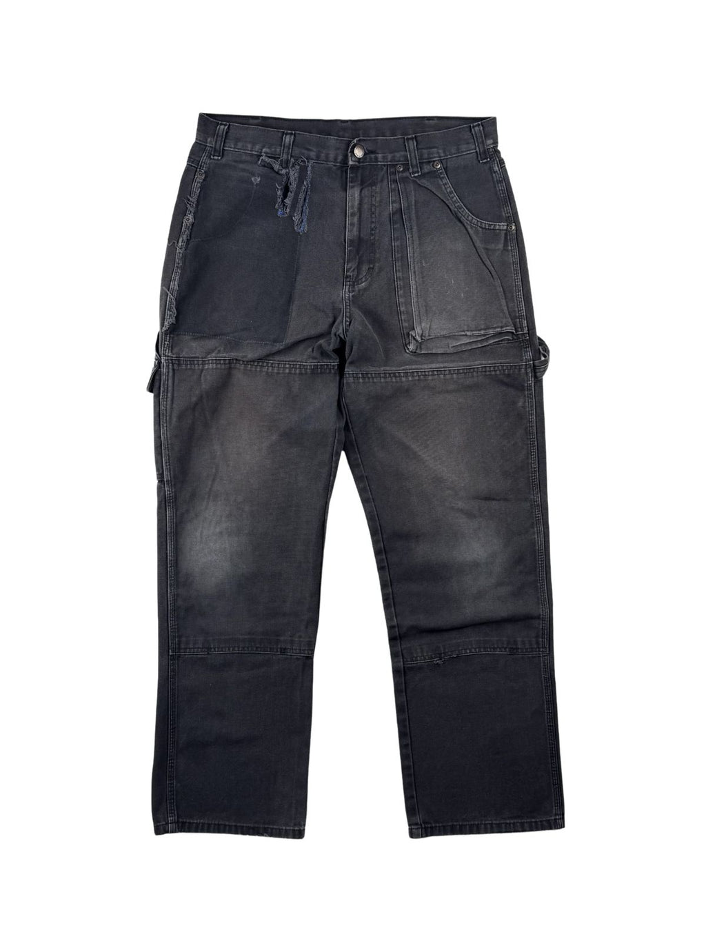 Vintage Dickies Double Knee Carpenter Hose in der kompletten Frontansicht. Ausgewaschene, anthrazit-schwarze Workwear-Hose im Thrashed-Look mit ausgeprägtem Kniefading, einem großen Stoffriss rechts und markantem Ghost-Pocket-Effekt rechts.