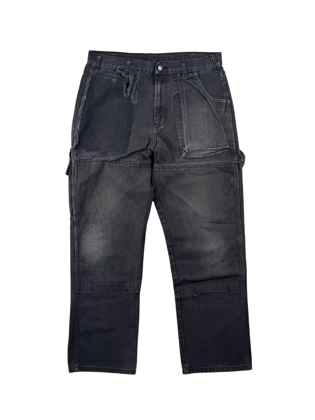 Vintage Dickies Double Knee Carpenter Hose in der kompletten Frontansicht. Ausgewaschene, anthrazit-schwarze Workwear-Hose im Thrashed-Look mit ausgeprägtem Kniefading, einem großen Stoffriss rechts und markantem Ghost-Pocket-Effekt rechts.
